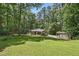 Charming home exterior with a lush lawn, detached garage, and mature trees offering privacy at 305 Old School Rd, Chapel Hill, NC 27516