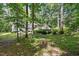 Exterior view of the home with mature trees and landscaping providing backyard privacy at 305 Old School Rd, Chapel Hill, NC 27516