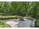 Outdoor fire pit with stone surround and wooded backyard providing tranquil privacy at 305 Old School Rd, Chapel Hill, NC 27516