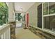 Covered front porch featuring stone accents, a red front door, and a view of the wooded surroundings at 305 Old School Rd, Chapel Hill, NC 27516