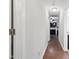 Hallway with hardwood floors leads to a living room with a fireplace and television in this beautifully staged home at 305 Old School Rd, Chapel Hill, NC 27516