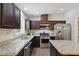 Modern kitchen featuring granite countertops, stainless steel appliances, and dark wood cabinets at 305 Old School Rd, Chapel Hill, NC 27516