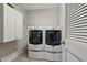 Laundry room with side-by-side washer and dryer, and white cabinets offering convenient storage options at 305 Old School Rd, Chapel Hill, NC 27516
