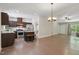 Open-concept living room showcasing hardwood floors and a view of the kitchen with a granite island at 305 Old School Rd, Chapel Hill, NC 27516