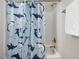Clean bathroom with shower/tub showcasing a fun shark-themed curtain, chrome fixtures, and neutral white tile at 305 Springtree Circle Cir, Fuquay Varina, NC 27526