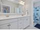 Bright bathroom featuring a double sink vanity, a large mirror, and stylish black and white tiled floors at 305 Springtree Circle Cir, Fuquay Varina, NC 27526