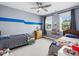 Cozy bedroom with carpeted floors, two beds, a ceiling fan, and ample natural light from the windows at 305 Springtree Circle Cir, Fuquay Varina, NC 27526