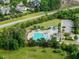 Aerial view featuring a sparkling community pool with lounge chairs, umbrellas, and nearby parking at 305 Springtree Circle Cir, Fuquay Varina, NC 27526