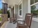 Cozy front porch with rocking chairs, stone pillars, and gray siding at 305 Springtree Circle Cir, Fuquay Varina, NC 27526