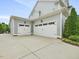 Three-car garage with white doors and concrete driveway, next to a well-manicured lawn at 305 Springtree Circle Cir, Fuquay Varina, NC 27526