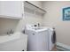 Functional laundry room featuring modern appliances, a sink, a storage shelf, and neutral paint at 305 Springtree Circle Cir, Fuquay Varina, NC 27526