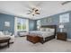 This bedroom is painted blue with a ceiling fan, hardwood flooring, and is illuminated by natural light at 305 Springtree Circle Cir, Fuquay Varina, NC 27526