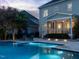 Back of the home with a screened porch, illuminated pool and lush landscape at 305 Springtree Circle Cir, Fuquay Varina, NC 27526