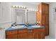 Bathroom featuring double sinks with an oak vanity and large mirrors at 307 Country Club Dr, Durham, NC 27712