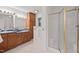 Bathroom featuring double sinks, wood cabinets, and a glass door shower at 307 Country Club Dr, Durham, NC 27712