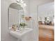 Bathroom features a pedestal sink, decorative mirror and views of the dining room at 307 Country Club Dr, Durham, NC 27712