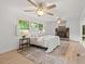 Bedroom with a brick fireplace, light wood floors, and light from three windows at 307 Country Club Dr, Durham, NC 27712