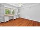 Empty room with wood floors, built-in shelves, a window, and a desk at 307 Country Club Dr, Durham, NC 27712