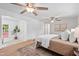Bright bedroom with wood floors, ceiling fan, access to a patio, and two accent paintings at 307 Country Club Dr, Durham, NC 27712