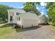 Side view of a white house with a two-car garage and gravel driveway under a sunny sky at 307 Country Club Dr, Durham, NC 27712
