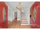 Bright foyer with hardwood floors, a wooden staircase, and a modern light fixture at 307 Country Club Dr, Durham, NC 27712