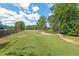 Scenic view of a lush green golf course with blue skies and scattered trees, providing a tranquil setting at 307 Country Club Dr, Durham, NC 27712