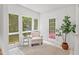 Bright sunroom with large windows, a chair, accent table, tile floor, and access to the outside at 307 Country Club Dr, Durham, NC 27712