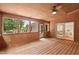 Charming sunroom with wood paneled walls, ceiling fan, and abundant natural light at 307 Country Club Dr, Durham, NC 27712