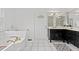 Bright bathroom featuring a soaking tub, black vanity, and tile flooring for a luxurious feel at 314 Lane Rd, Dunn, NC 28334
