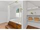 Luxurious bathroom featuring a jacuzzi tub, wooden steps, white shelves with décor items, and fresh white paint at 314 Lane Rd, Dunn, NC 28334