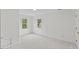 Bright bedroom featuring neutral carpet, two windows offering ample natural light, and fresh white paint at 314 Lane Rd, Dunn, NC 28334