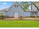 Rear exterior featuring a well-maintained yard, brick patio with seating, and a charming blue house at 314 Lane Rd, Dunn, NC 28334
