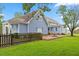 Rear view of a two-story home with a fenced yard, patio, and well-manicured lawn at 314 Lane Rd, Dunn, NC 28334