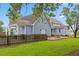 Spacious backyard with lush lawn and mature trees, surrounding a charming home with multiple outdoor spaces at 314 Lane Rd, Dunn, NC 28334