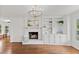 Bright living room featuring hardwood floors, built-in bookshelves, and a cozy fireplace at 314 Lane Rd, Dunn, NC 28334