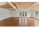 Hardwood floored living room with neutral paint, unique wood ceiling, and natural light from large windows at 314 Lane Rd, Dunn, NC 28334