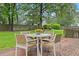 Cozy outdoor patio featuring a table and chairs, surrounded by lush greenery and a fenced yard at 314 Lane Rd, Dunn, NC 28334