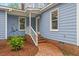 Inviting side entrance with brick pathway leading to the charming blue house and well-maintained landscaping at 314 Lane Rd, Dunn, NC 28334