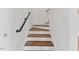 Elegant staircase featuring wooden treads, white risers, and a modern black handrail, freshly painted white walls at 314 Lane Rd, Dunn, NC 28334
