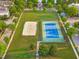 Aerial view of a community featuring a tennis court, sand volleyball court, green spaces, and tree-lined streets at 321 Commons Walk Cir, Cary, NC 27519