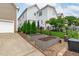 Exterior of a home showcasing raised garden beds, lush greenery, and a well-maintained lawn at 321 Commons Walk Cir, Cary, NC 27519