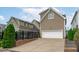 Home exterior with a driveway leading to a garage, complemented by landscaping and a fenced-in backyard at 321 Commons Walk Cir, Cary, NC 27519