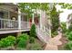 Charming front porch with white railings and a red door, surrounded by lush landscaping at 321 Commons Walk Cir, Cary, NC 27519