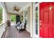 Welcoming front porch with ample seating, ceiling fan, and a vibrant red front door at 321 Commons Walk Cir, Cary, NC 27519