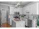 Well-lit kitchen features shaker cabinets, island, stainless appliances and modern lighting at 321 Commons Walk Cir, Cary, NC 27519