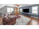 Living room area with hardwood floors, ceiling fan, TV, sofa and natural light at 321 Commons Walk Cir, Cary, NC 27519