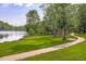 Scenic walking path along the lake surrounded by lush greenery and mature trees at 321 Commons Walk Cir, Cary, NC 27519