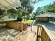 View from the wooden porch to the backyard with grass and a detached garage at 3810 Pendergrass St, Durham, NC 27704