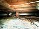 View of the crawlspace under the home, showing pipes, wiring, and a brick support at 3810 Pendergrass St, Durham, NC 27704