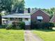 Charming single-story home with a brick and siding exterior, inviting front yard, and covered porch at 3810 Pendergrass St, Durham, NC 27704